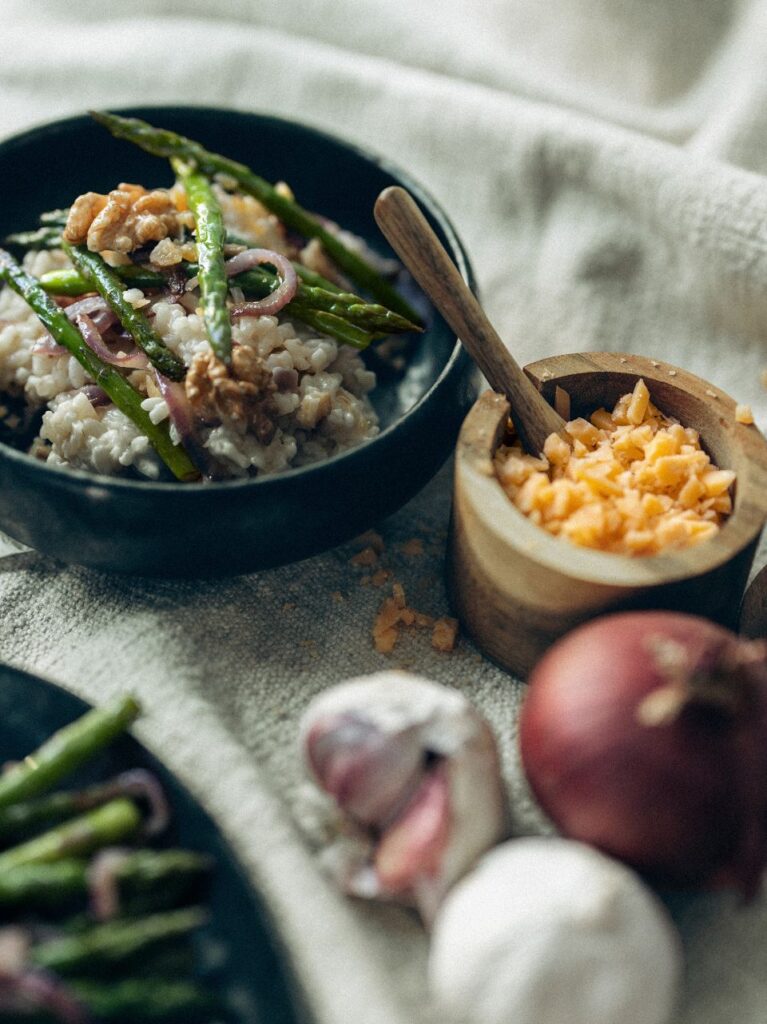 Romige risotto met groene asperges, oude kaas en walnoten