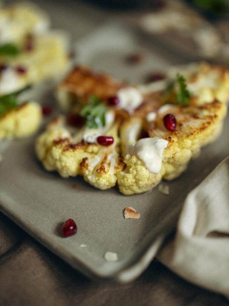 Bloemkoolsteak met yoghurt-kerriesaus en granaatappelpitjes