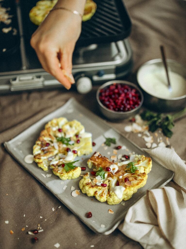 Bloemkoolsteak met yoghurt-kerriesaus en granaatappelpitjes